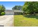 Charming single-story home with manicured lawn, attached two-car garage, and mature trees at 1425 Meadowind Court Sw, Conyers, GA 30094