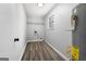 Clean laundry room with wood-look floors, shelving, and utility connections at 1425 Meadowind Court Sw, Conyers, GA 30094