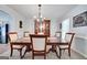 Bright dining room featuring a chandelier, wainscoting, and a wooden table with six chairs at 212 Warrenton Dr, Douglasville, GA 30134