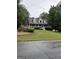 Charming two-story home with a classic design, front porch, manicured lawn, and mature trees at 212 Warrenton Dr, Douglasville, GA 30134