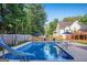 Large in-ground backyard pool featuring a slide, lounge furniture, umbrellas, and deck at 212 Warrenton Dr, Douglasville, GA 30134