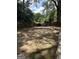 Large backyard with an outdoor patio and a spacious lawn surrounded by mature trees and wooden fence at 1055 Worthington Hills Dr, Roswell, GA 30076