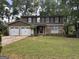 Charming two-story home with a two-car garage and stone accents in a well-maintained lawn at 1055 Worthington Hills Dr, Roswell, GA 30076