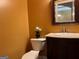Powder room with a decorative mirror, toilet, and pedestal sink at 1218 Heartwood Ave, Mcdonough, GA 30253
