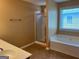Bathroom with a walk-in shower, tile floors, separate tub, and a large window at 1218 Heartwood Ave, Mcdonough, GA 30253