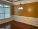 Bright dining room with modern chandelier, decorative molding, and dark wood flooring at 1218 Heartwood Ave, Mcdonough, GA 30253