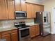 Kitchen with stainless steel appliances, tile backsplash, granite counters, and wood cabinetry at 1218 Heartwood Ave, Mcdonough, GA 30253