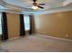 Large main bedroom with tray ceilings and two large windows with curtains at 1218 Heartwood Ave, Mcdonough, GA 30253