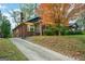 Brick home exterior showcasing a front yard tree with red-orange leaves and a long concrete driveway at 1660 Rogers Sw Ave, Atlanta, GA 30310