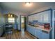 Galley kitchen with blue cabinets, modern appliances, mosaic tile backsplash and window to backyard at 1660 Rogers Sw Ave, Atlanta, GA 30310