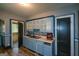 Galley kitchen featuring painted cabinets, laminate counters and gray tiled backsplash at 1660 Rogers Sw Ave, Atlanta, GA 30310