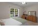 Neutral bedroom features a window providing natural light, dresser, and desk at 175 N Unity Grove Rd, Locust Grove, GA 30248