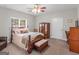 Cozy bedroom features a wooden bed frame, ceiling fan, and natural light from a large window at 175 N Unity Grove Rd, Locust Grove, GA 30248