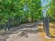 Long driveway behind a black iron gate surrounded by mature trees at 175 N Unity Grove Rd, Locust Grove, GA 30248
