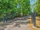 Gated driveway leading to a secluded property surrounded by lush greenery and trees at 175 N Unity Grove Rd, Locust Grove, GA 30248