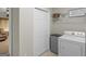 Practical laundry room featuring a washer, dryer, storage shelf, and closet for efficient household chores and organization at 175 N Unity Grove Rd, Locust Grove, GA 30248