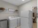 Practical laundry room features a washer, dryer, refrigerator, and convenient shelving for organized storage at 175 N Unity Grove Rd, Locust Grove, GA 30248