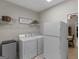 Functional laundry room with white appliances, storage and shelving at 175 N Unity Grove Rd, Locust Grove, GA 30248