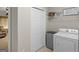 Well-organized laundry area with a washer, dryer, and overhead shelving, providing efficient space for chores at 175 N Unity Grove Rd, Locust Grove, GA 30248