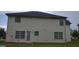 Rear exterior of home showcasing white siding, multiple windows, and a backyard at 11950 Markham Way, Hampton, GA 30228