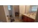 Bathroom with double sinks, wood cabinets, and an open doorway to an additional space at 11950 Markham Way, Hampton, GA 30228