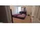 Bedroom with a large window, dresser, mirror and a bed with purple floral bedding at 11950 Markham Way, Hampton, GA 30228