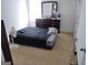 Carpeted bedroom with window and a dresser with large mirror for storage, along with fan at 11950 Markham Way, Hampton, GA 30228