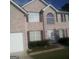 Two-story brick home featuring an attached garage, a manicured lawn, and large windows at 11950 Markham Way, Hampton, GA 30228