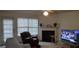 Living room featuring a fireplace, ceiling fan, and a television on in the background at 11950 Markham Way, Hampton, GA 30228