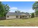 Back exterior of home with a large backyard, patio, and wooden fence at 100 Gum Creek Landing, Oxford, GA 30054