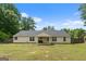 Spacious backyard featuring a covered patio, grassy lawn, and a charming single-story home at 100 Gum Creek Landing, Oxford, GA 30054