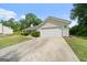 View of the home and driveway showing attached two car garage and lawn at 100 Gum Creek Landing, Oxford, GA 30054