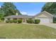 Charming single-story home featuring a manicured lawn and attached two car garage at 100 Gum Creek Landing, Oxford, GA 30054