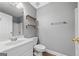 This bathroom features a white vanity, updated lighting, shelving and a shower with glass door at 175 Dove Pt, Covington, GA 30016