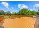 Large wooden deck with stairs overlooks a green backyard with lush trees on a sunny day at 175 Dove Pt, Covington, GA 30016