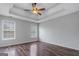 Main bedroom with wood floors, a tray ceiling and natural light from windows at 175 Dove Pt, Covington, GA 30016