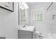 Bright bathroom with modern vanity, square mirror, decorative flower, tiled shower, and a window at 2425 Clifton Springs Rd, Decatur, GA 30034