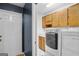 Laundry room with tiled flooring, ample cabinet storage, and modern, stacked washer and dryer units at 332 Judy Dr, Mcdonough, GA 30253
