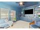 Modern living room with dark blue walls, built-in shelving, and comfortable seating near bright windows at 332 Judy Dr, Mcdonough, GA 30253