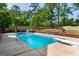 Swimming pool surrounded by green trees, lounge chairs, and tiered garden at 332 Judy Dr, Mcdonough, GA 30253