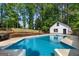 Backyard in-ground swimming pool with a deck area and lush landscaping with a detached garage in view at 332 Judy Dr, Mcdonough, GA 30253