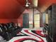 Cozy bonus room featuring a black leather sofa, a funky rug, and dark colors at 3970 Lagrone St, Powder Springs, GA 30127