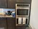 Modern kitchen with stainless steel appliances, granite countertops, and dark wood cabinetry at 3970 Lagrone St, Powder Springs, GA 30127