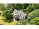 Bird's-eye view of a brick house with double porches, complemented by a verdant canopy of trees at 218 Woodruff Way, Peachtree City, GA 30269
