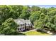 Scenic aerial view of a brick home with a double porch, surrounded by lush, mature trees at 218 Woodruff Way, Peachtree City, GA 30269