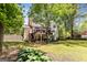 Large and private backyard showcasing a raised wooden deck, lush greenery, and retaining wall at 218 Woodruff Way, Peachtree City, GA 30269