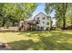 Lovely two-story home showing the wooden deck, lower patio, and a large, open grassy yard at 218 Woodruff Way, Peachtree City, GA 30269