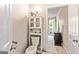 Cozy powder room with a toilet, small sink, and a decorative cabinet at 218 Woodruff Way, Peachtree City, GA 30269