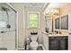 Bathroom featuring a vanity with a decorative mirror, wood-look flooring, and a glass shower at 218 Woodruff Way, Peachtree City, GA 30269
