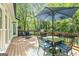 Outdoor deck furnished with a dining table, grill, and seating, perfect for entertaining and enjoying the scenery at 218 Woodruff Way, Peachtree City, GA 30269